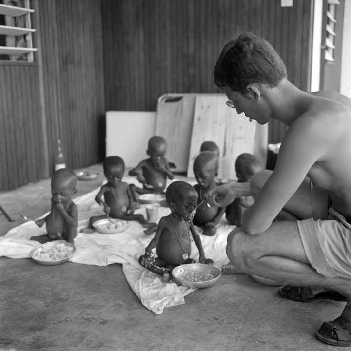 Enfants venus du Biafra, dénutris,&nbsp;nourris par un&nbsp;assistant médical, dans un hôpital&nbsp;militaire français à Libreville (Gabon), le 15 mars 1969 (- / AFP)