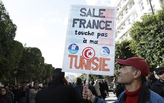 Un manifestant pro-Ennahda brandit une pancarte d&eacute;non&ccedil;ant l'action de la France, le 16 f&eacute;vrier 2013, lors d'un rassemblement &agrave; Tunis.&nbsp; (ZOUBEIR SOUSSI / REUTERS)