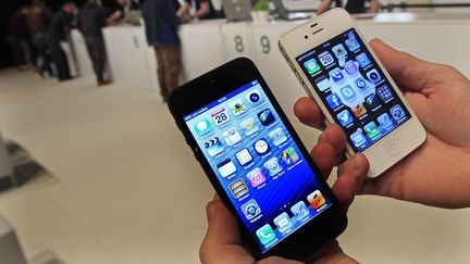 Un Iphone 5 (&agrave; gauche), le dernier n&eacute; de la gamme de t&eacute;l&eacute;phone Apple, et son pr&eacute;d&eacute;cesseur l'Iphone 4, dans un magasin de Bruxelles (Belgique) en septembre 2012. ( YVES HERMAN / REUTERS)