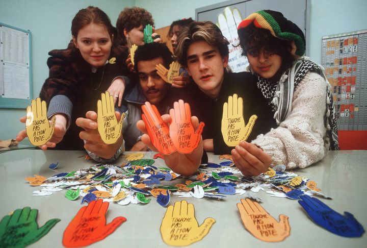 Des élèves du lycée&nbsp;Stephen Liégeard à Brochon (Côte d'Or) présente des badges "Touche pas à mon pote" qu'ils ont créés, le 4 février 1985. (AFP)