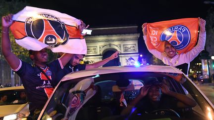 Des supporters du PSG fêtent la victoire du club face à Leipzig, en demi-finale de la Ligue des champions, le 18 août 2020 sur les Champs-Elysées à Paris. (BERTRAND GUAY / AFP)