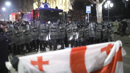 Des policiers barrent la route à des manifestants à Tbilissi (Géorgie), le 9 mars 2023. (DAVID MDZINARISHVILI / ANADOLU AGENCY / AFP)