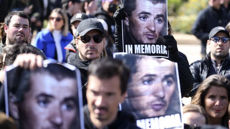 Des manifestants tiennent des portraits d'Yvan Colonna lors d'une manifestation à Ajaccio après la mort du nationaliste corse, le 3 avril 2022. (PASCAL POCHARD-CASABIANCA / AFP)