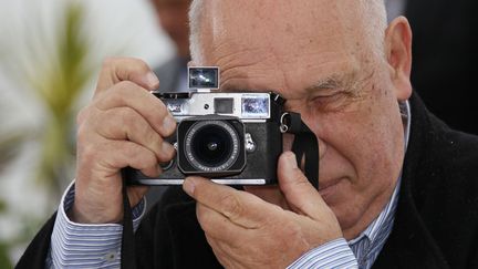 M&ecirc;me planqu&eacute; derri&egrave;re son vieux Leica, on reconna&icirc;t&nbsp;le photographe Raymond Depardon, &agrave; Cannes pour pr&eacute;senter son "Journal de France". (YVES HERMAN / REUTERS)