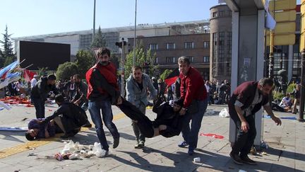 &nbsp; (Un blessé porté par deux manifestants, après une double explosion devant la gare d'Ankara © REUTERS Photographer)