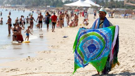 Sur la plage de Sousse (nord-ouest de la Tunisie), un vendeur tente sa chance auprès des touristes le 22 juin 2018. (ZOUBEIR SOUISSI / X02856)