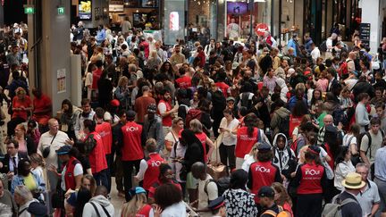 Des agents SNCF renseignent les passagers dont les voyages ont été annulés à cause des dégradations sur des lignes LGV, à la gare Montparnasse, le 26 juillet 2024. (THIBAUD MORITZ / AFP)