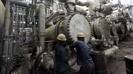 Des ouvriers nigérians intervenant dans une raffinerie de pétrole à Port Harcourt (sud du Nigeria), le 16 septembre 2015. (PIUS UTOMI EKPEI / AFP)