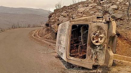 Une voiture carbonisée après un incendie à Toudja, en Algérie, le 24 juillet 2023. (FACEBOOK PAGE OF RADIO SOUMMAM BEJAIA / AFP)