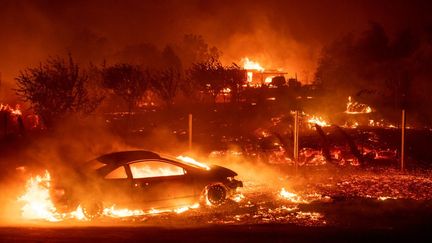 Une voiture et des maisons brûlent dans la ville de Paradise (Californie), aux Etats-Unis, le 8 novembre 2018. (JOSH EDELSON / AFP)