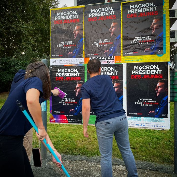 Des adhérents du mouvements des "Jeunes Avec Macron" collent des affiches de campagne devant la mairie de Lille. (MANON MELLA / FRANCEINFO)