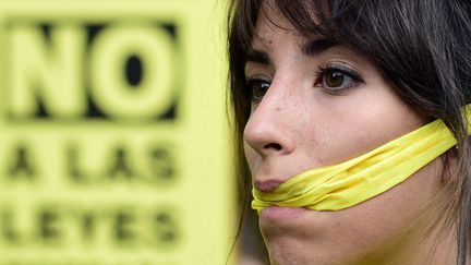 Non à la «loi bâillon». Photo d'une manifestante protestant, le 30 juin 2015 à Madrid, contre une loi du gouvernement Rajoy, destinée à mieux contrôler les mouvements sociaux. (JAVIER SORIANO / AFP)