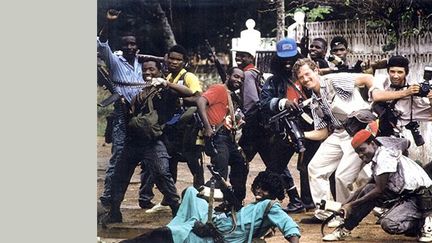 Peter Jouvenal de Frontline News Television (FNTV) et le photographe Patrick Robert avec des guérilleros au Liberia, en 1991.
 
Peter Jouvenal est l’un des créateurs de FNTV.
 
Patrick Robert est un reporter-photographe depuis près de trente ans. Il a couvert de nombreux conflits en Afrique, en Asie, au Proche et Moyen-Orient et en Europe de l’Est. Il a été très gravement blessé par balles au Liberia en 2003.
 
Son travail a été récompensé par une douzaine de prix internationaux dont deux Visa d’or au festival de photo-journalisme à Perpignan. (© FNTV)