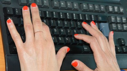 Une femme tape sur un clavier d'ordinateur au travail. (JEAN-CHRISTOPHE BOURDILLAT / RADIO FRANCE)