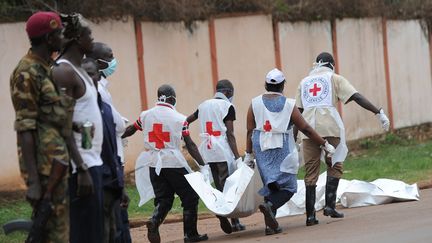 Des membres de la Croix-rouge recherchent des corps sur le site des affrontements, &agrave; Bangui (Centrafrique), le 6 d&eacute;cembre 2013. (SIA KAMBOU / AFP)