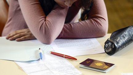 Une &eacute;tudiante travaille sur le bac philosophie, &agrave; Paris, le 16 juin 2014. (FRED DUFOUR / AFP)