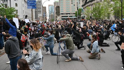 A Montréal, des manifestants observent une minute de silence, un genou à terre, en hommage à George Floyd, le 31 mai 2020.&nbsp; (ERIC THOMAS / AFP)