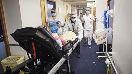 Des ambulanciers transfèrent une nouvelle patiente dans l'une&nbsp;des unités Covid-19 de l'Institut Mutualiste Montsouris à Paris, le 6 mai 2021.&nbsp; (ANTONIN BURAT / HANS LUCAS / AFP)