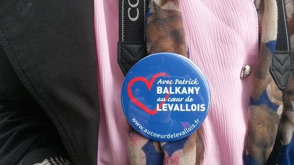 Une Levalloisienne arbore un badge de soutien &agrave; Patrick Balkany, mardi 9 juin 2015, devant le si&egrave;ge de France T&eacute;l&eacute;visions, &agrave; Paris. (F. MAGNENOU / FRANCETV INFO)