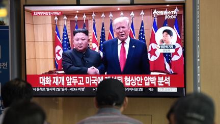 Des personnes regardent à la télévision la rencontre entre&nbsp;Kim Jong-un et Donald Trump, à Séoul (Corée du Sud), le 25 juillet 2019. (JUNG YEON-JE / AFP)