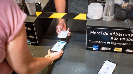 Une personne présente un pass sanitaire, le 16 août 2021 à Perpignan (Pyrénées-Orientales). (ARNAUD LE VU / HANS LUCAS / AFP)