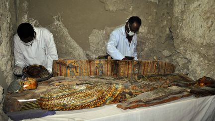 Des membres d'une équipe archéologique égyptienne inspectent des sarcophages, le 18 avril 2017, dans la&nbsp;nécropole de Dra Abou El-Naga, près de Louxor (Egypte). (STRINGER / AFP)