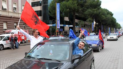 Des Albanais brandissent des drapeaux de l'Albanie et de l'Union européenne, à Tirana, en Albanie, le 8 novembre 2010. (GENT SHKULLAKU / AFP)