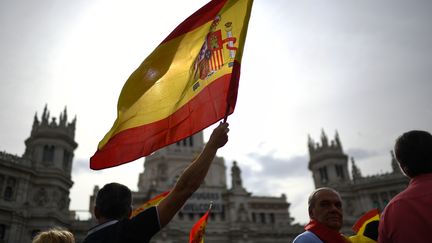 Un homme brandit un drapeau espagnol lors d'une manifestation contre le référendum d'autodétermination en Catalogne, le 30 septembre 2017, à Madrid. (GABRIEL BOUYS / AFP)