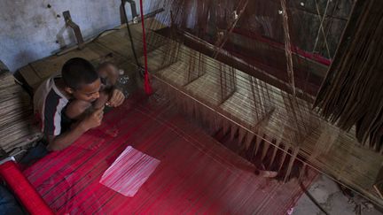 &nbsp; (Un garçon employé dans une fabrique de saris au Bangladesh © MaxPPP)