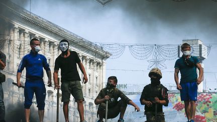 Des activistes masqu&eacute;s dans un campement de la place Ma&iuml;dan, &agrave; Kiev, jeudi 7 ao&ucirc;t 2014.&nbsp; (SERGEY DOLZHENKO / MAXPPP)