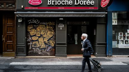 Une habitant passe samedi 25 mai devant&nbsp;la boulangerie Brioche dorée, rue Victor-Hugo à Lyon, où a eu lieu l'explosition la veille&nbsp;d'un colis piégé, qui a fait 13 blessés.&nbsp; (JEFF PACHOUD / AFP)