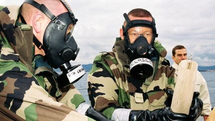 Des marins recherchent du gaz sarin dans des bouteilles plastiques, le 28 novembre 2003, lors d'un exercice inédit de lutte internationale antiterroriste. (MARINE NATIONALE / AFP )