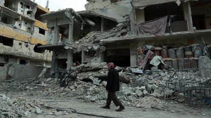 Un homme dans une rue de la Ghouta orientale, fief rebelle, près de Damas, la capitale syrienne, le 25 février 2018. (HAMZA AL-AJWEH / AFP)