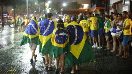 Comme un symbole, des trombes d'eau se sont abattues sur Rio lorsque les supporters, d&eacute;pit&eacute;s, rentraient chez eux apr&egrave;s le match. (JORGE SILVA / REUTERS)