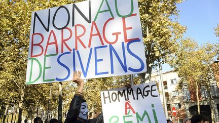 Un manifestant brandit deux pancartes lors d'une manifestation devant la pr&eacute;fecture d'Albi (Tarn), le 27 octobre 2014. (REMY GABALDA / AFP)