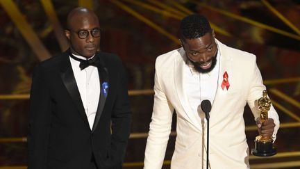 Barry Jenkins (à gauche) et Tarell Alvin McCraney reçoivent le prix du meilleur scénario pour "Moonlight" à la cérémonie des Oscars, au&nbsp;Dolby Theatre, à Los Angeles, le 26 février 2017. (CHRIS PIZZELLO/AP/SIPA)