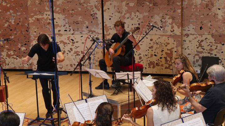 Thibault Cauvin avec le chef Julien Masmondet et une partie de l'Orchestre de chambre de Paris.
 (Lorenzo Ciavarini Azzi/Culturebox)