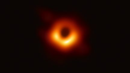 Voici la première image d'un trou noir. Celle-ci a été obtenue par interférométrie et présentée à la presse&nbsp;mercredi 10 avril 2019. L'objet céleste est situé dans la galaxie M87, située à une distance de 53,5 millions d'années-lumière. (JIN LIWANG / XINHUA / AFP)