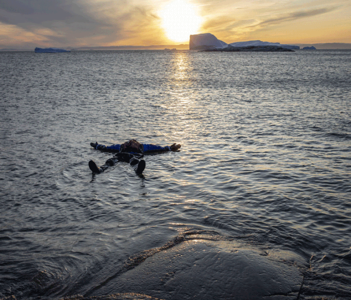 A Ilulissat, un touriste fait la planche sur les flots glacés (entre -1,1°et 6,5°C). (MARCO ZORZANELLO/ GEO)