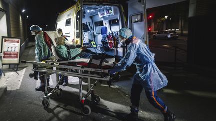 Des soignants transportent un homme dans un hôpital parisien, le 3 avril 2020. (LUCAS BARIOULET / AFP)