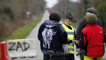 Un gendarme contr&ocirc;le l'identit&eacute; de festivaliers &agrave; l'entr&eacute;e de la ZAD, la zone d'am&eacute;nagement diff&eacute;r&eacute; du projet d'a&eacute;roport du Grand Ouest, &agrave; Notre-Dame-des-Landes, vendredi 4 janvier 2013.&nbsp; (STEPHANE MAHE / REUTERS)