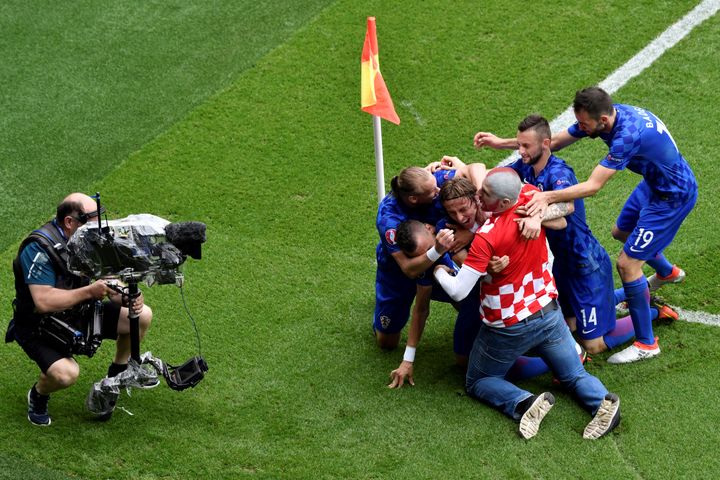 Un fan célèbre le but de Luka Modric au milieu des joueurs croates, après avoir déjoué la sécurité du parc des Princes, dimanche 12 juin 2016. (PHILIPPE LOPEZ / AFP)