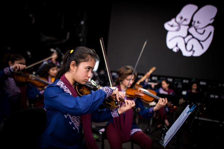 Les violonistes de l'orchestre Zohra s'accordent avant leur concert à Bratislava le 16 juillet 2019. (VLADIMIR SIMICEK / AFP)