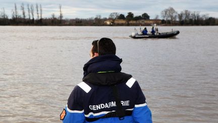 Un gendarme surveille la Dordogne (Gironde), deux jours apr&egrave;s un crash d'h&eacute;licopt&egrave;re&nbsp;pr&egrave;s de Libourne, le 20 d&eacute;cembre 2013. (JULIE BRUHIER / AFP)