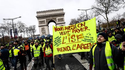 "Nous aussi, on veut payer l'ISF" proclame cette banderole brandie devant l'Arc de triomphe. (SAMEER AL-DOUMY / AFP)