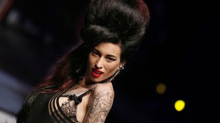 Une mannequin d&eacute;guis&eacute;e en Amy Winehouse pr&eacute;sente un mod&egrave;le du cr&eacute;ateur fran&ccedil;ais Jean-Paul Gaultier lors de la fashion week &agrave; Paris, le 28 septembre 2013. (MAXPPP)