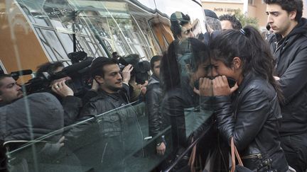 Une jeune femme r&eacute;agit au passage d'un corbillard transportant le cercueil d'une des victimes de la tuerie de Toulouse, le 20 mars 2012. (PASCAL PARROT / REUTERS)