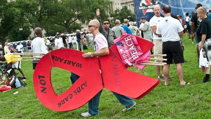 Un activiste porte un ruban rouge g&eacute;ant lors d'un rassemblement en marge de la 19e conf&eacute;rence internationale sur le sida, &agrave; Washington (Etats-Unis), le 22 juillet 2012. (NICHOLAS KAMM / AFP)