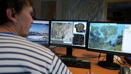 Un homme regarde des écrans à la station météo de Chamonix (Haute-Savoie), le 26 décembre 2012, pour préparer des prévisions et évaluer le risque d'avalanche. (JEAN-PIERRE CLATOT / AFP)