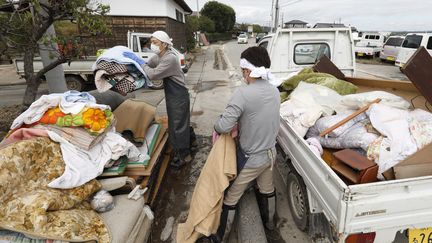 Des habitants font du tris dans leurs affaires après le passage du typhon Hagibis, dans la préfecture d'Ibaraki, le 15 octobre 2019. (NAOKI MAEDA / YOMIURI / AFP)